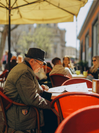 Rome, Italy- April 2, 2023:Italien old Man, reading newspaper in cafe in Romeのeditorial素材