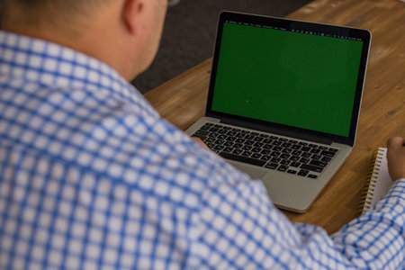 Cropped image of man working on a laptop at home