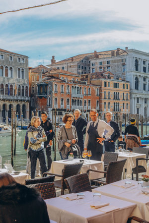 VENICE, ITALY - April 2. 2023: People are sitting at the outside terrace of a small cafe in Venice, Italy.のeditorial素材