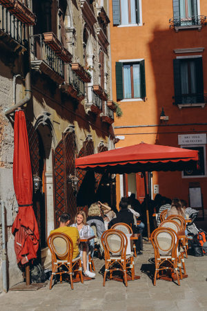 VENICE, ITALY - April 2. 2023: People are sitting at the outside terrace of a small cafe in Venice, Italy.のeditorial素材