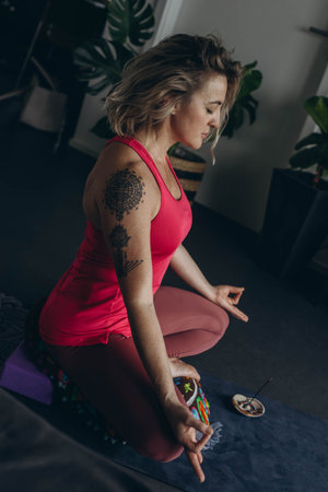 woman practices yoga and meditates in the lotus position at home
