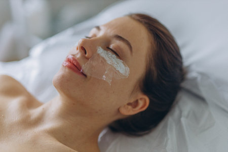 A professional beautician injects Botox into the face of a young woman