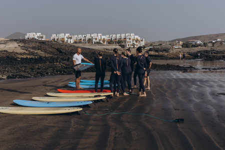 Canary Island, Tenerife-December14,2023.surfers going for surfing in the ocean.Coach show how to surf to the groupのeditorial素材