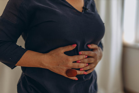 A woman places her hands on her stomach, performing external techniques as part of diaphragmatic breathing. High quality photoの写真素材
