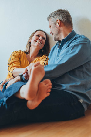 A happy couple is having fun at home while sitting on the floor.の写真素材