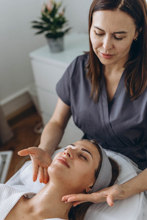 A beautiful woman enjoys a facial massage at a spa salon, indulging in skin and body care treatments. High quality photoの写真素材