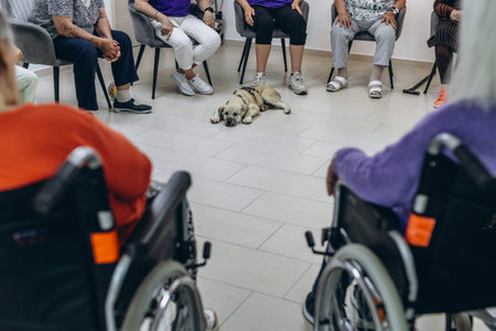 Group of elderly people in a nursing home spending time with their friendly dog. High quality photoの写真素材
