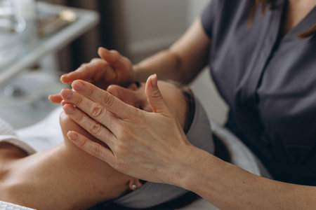 A beautiful woman enjoys a facial massage at a spa salon, indulging in skin and body care treatments. High quality photoの写真素材
