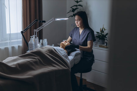 Middle aged woman receiving facial cleansing and care at a cosmetologist office. High quality photoの写真素材