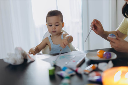 Little boy and his mother painting eggs together. Easter celebration and motherhood bonding conceptの写真素材