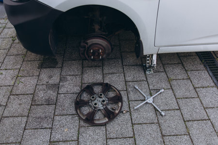 Repairing the breaks of a car after a street crash. Details and focus on metal parts and worn out disc, Close up disc brake without wheels of the vehicle for repair.の写真素材