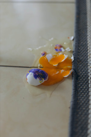 broken egg in floor, symbolizing Easter mishaps and holiday preparations. Easter celebration concept