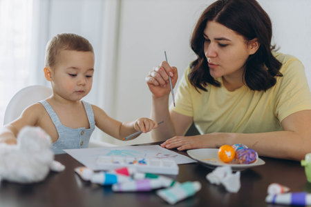 Little boy painting with his mother,enjoying creative moment together.Motherhood,parenting concept