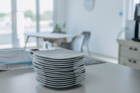 Stack of white plates prepared for serving, clean and ready for table setting.の写真素材