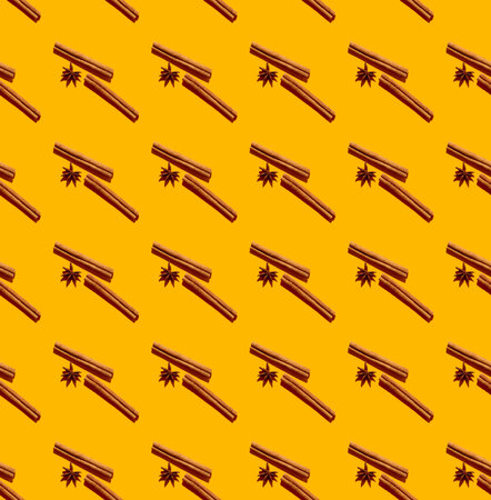 Cinnamon quills and star anise fruits seamless pattern isolated on yellow as a backgroundの写真素材