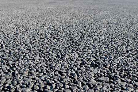 Closeup of an asphalt road. Background photo in perspective with selective focusの写真素材