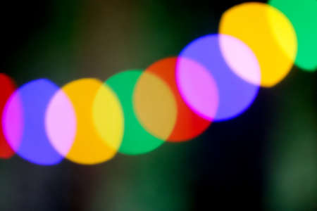 String of blurred multicolored holiday lights as a defocused background