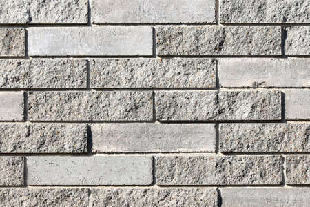 Texture of a wall made of rectangular blocks of different surface roughness as a background
