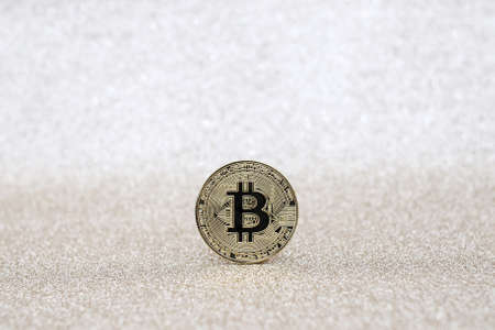 Bitcoin on a glittering white background with copy space. Photo with selective focus