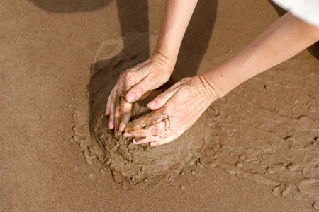 Making sandcastle on the beach. Leisure creative activity in summerの写真素材