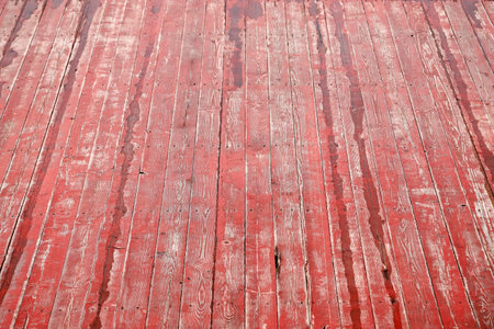 An old wet wooden pavement painted in red on a rainy day. Photo in perspective with selective focusの写真素材