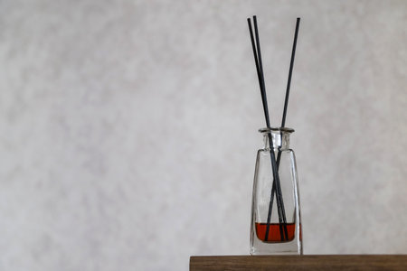 Closeup of a reed diffusor in domestic interior. Cozy home atmosphere. Concept of relaxation with aromatherapy. Photo with copy spaceの写真素材