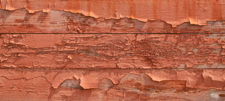 Closeup of texture of an old cracked wooden wall covered with old peeled orange paint as a backgroundの写真素材