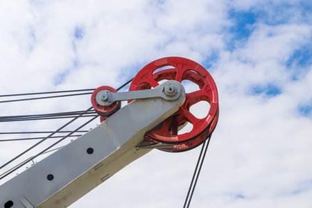 Closeup of the lifting block of the open-mine excavator against a cloudy sky