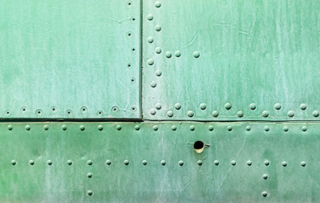 Closeup of the riveted with button-head rivets metal plate - side of an military vehicle - painted...