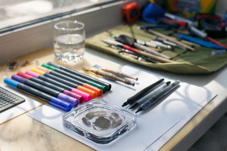 Painter, graphic designer or calligraphy work space, different kind of tools, brushes, marker and...