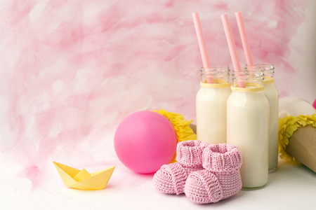 Baby shower decorative table with copy space, pink baby girl booties and bottles with milk in pastel background, idea of baby shower decorの写真素材