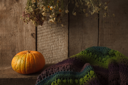Pumpkin, dry flowers and woolen scarf on wooden background, Thanksgiving, coutryside And Fall Backgroundの写真素材