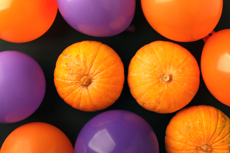 holidays, decoration and party concept - pumpkins, air balloons for halloween over black backgroundの写真素材