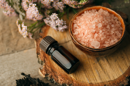 autumn spa and aromatherapy, Autumn fall spa still life wellness setting concept. Assortment of essential oil, sea salt, candles dry flowers and cones on a rustic wooden table. Copy space backgroundの写真素材