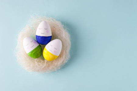 funny cute eggs in the nest jon blue pastel background, trendy unplug relaxation concept