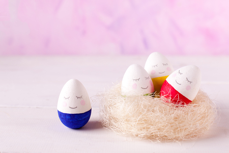 a group of funny colorful eggs - a concept of merry Easter, funny characters, emotions. One against allの写真素材