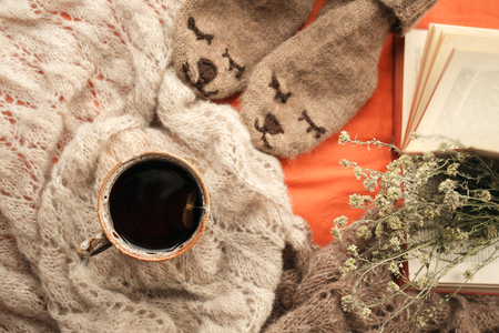 Still life details of living room. Cup of tea on woollen blanket and cute hipster bear socks in the bed. Autumn fall winter weekend concept. Fall home decoration. Flat layの写真素材