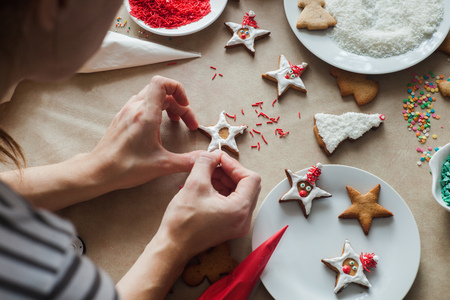 mother decorate homemade christmas cookies with glazeの写真素材