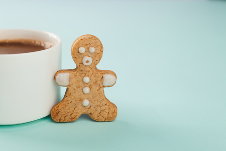 gingerbread man stands near a white mug, copy spaceの写真素材