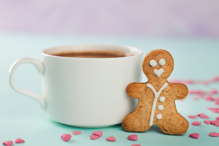 loving gingerbread man stands near a white mugの写真素材