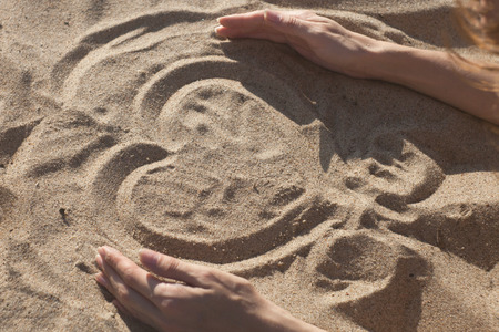 Conceptual heart shape hand-drawn in sand on a beach