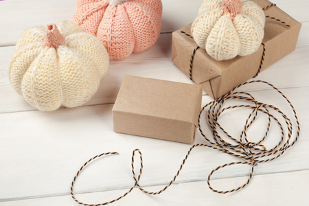 Halloween preparation. Halloween background with decorative pumpkin, gift box on white wooden background. Festive concept.の写真素材