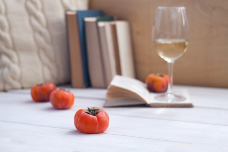 Still life interior details, glass of wine, opened book, pillow. Lazy winter weekend, readiing conceptの写真素材