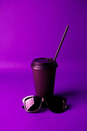 Black Coffee to go cup and black sunglass in vibrant bold gradient holographic colors. Concept art. Minimal hipster surrealism, coffee take away conceptの写真素材