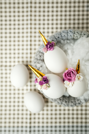 Cute creative photo with easter eggs in the nest, unicorn with flower decor - creative idea for ester partyの写真素材
