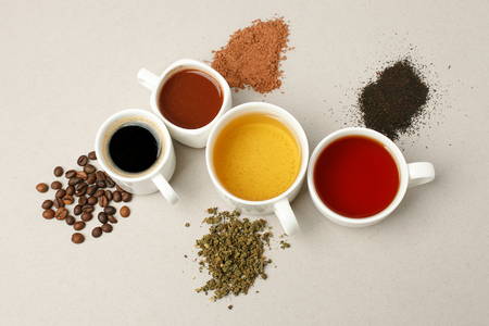 Time for a coffee break or teatime. Many different mugs and white cups  containing freshly brewed coffee, cocoa and tea for a daily dose of caffeine to energize day.の写真素材