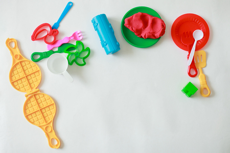 Set of play dough and plastic cutting block and other tools on whiteの写真素材