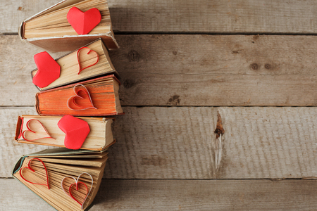 Various old books and origami paper craft red heart on vintage woodenの写真素材