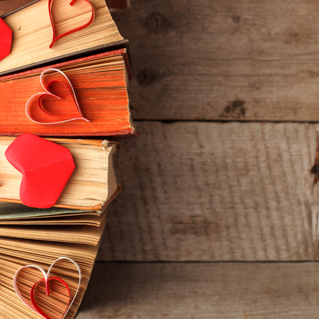 Various old books and origami paper craft red heart on vintage woodenの写真素材