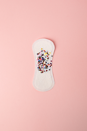 Feminine hygiene pad with festive confetti on pinkの写真素材